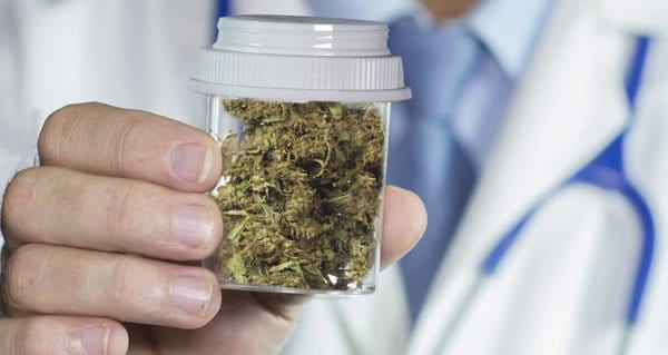 Medical Cannabis Overview. Doctor holding bud in a bottle.