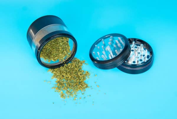 weed and weed grinder on blue, Tips to Breaking Up Cannabis Without a Weed Grinder
