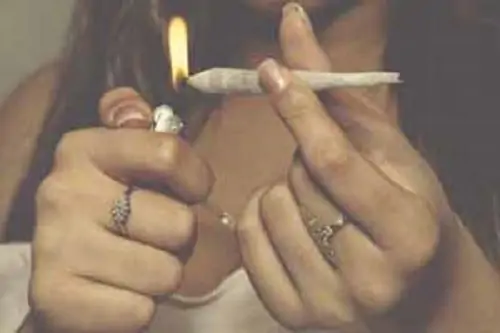 Physical Exercise and the Marijuana Effect. Lady lighting blunt.