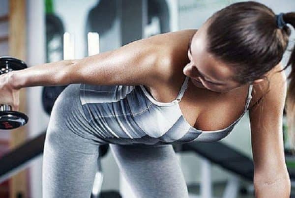 How to Use CBD Oil to Recover From Your Gym Session. Woman lifting weights.