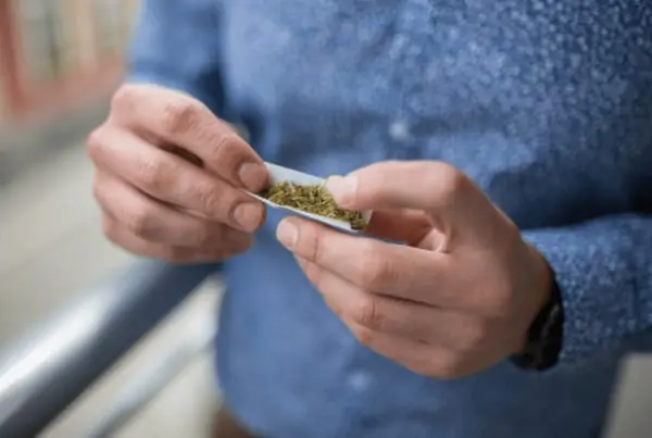 How to Discuss Marijuana Use With Others. A man rolling a joint