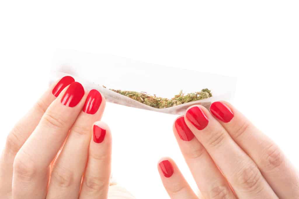 Female Marijuana Influencers Who Have Impacted The Industry. Two hands holding a joint.
