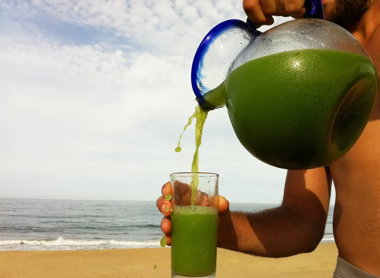 Does Juicing Raw Marijuana Help with Lupus? Green juice being poured into a glass.