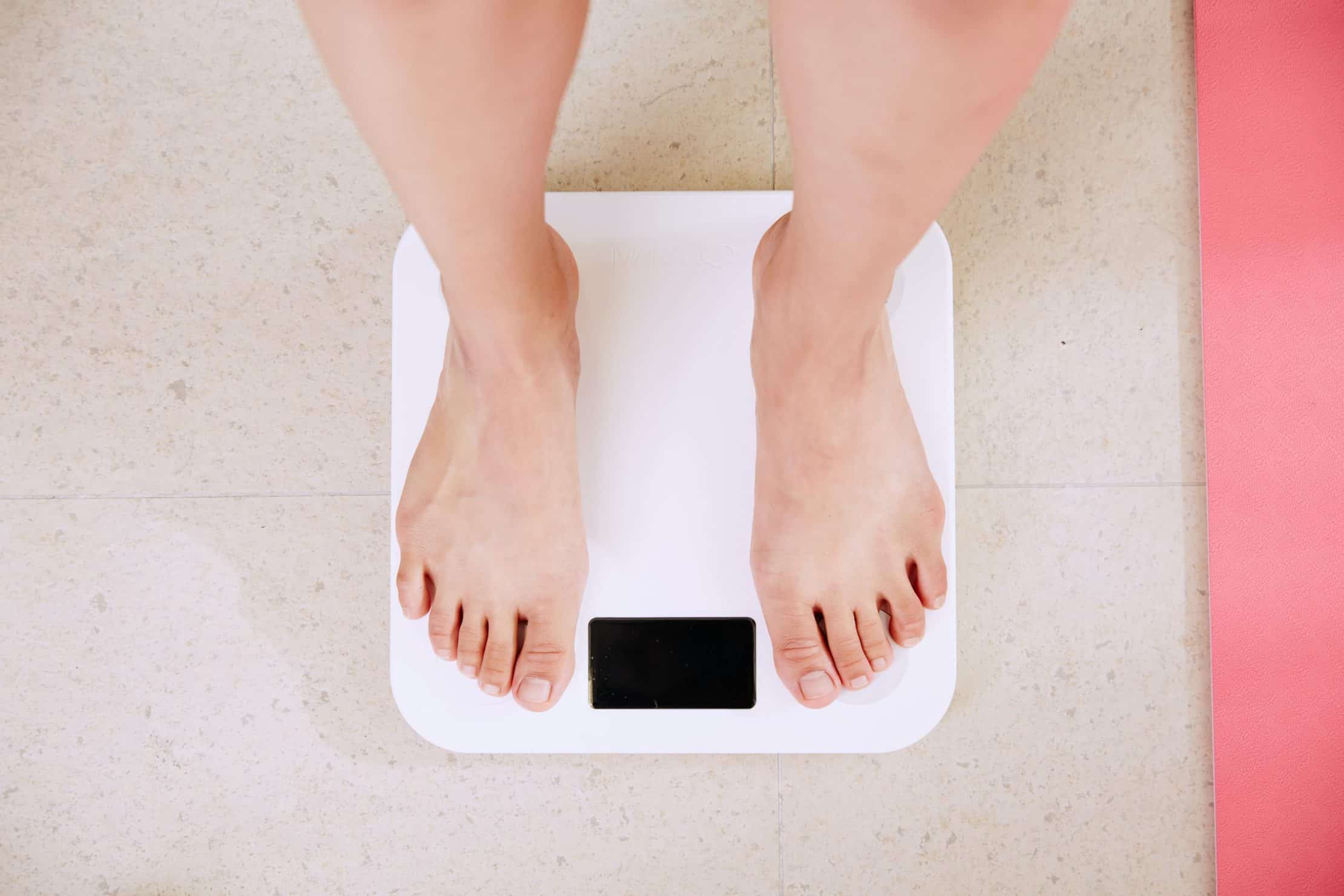 Top 10 Cannabis Strains To Reduce Obesity. Women on a scale.