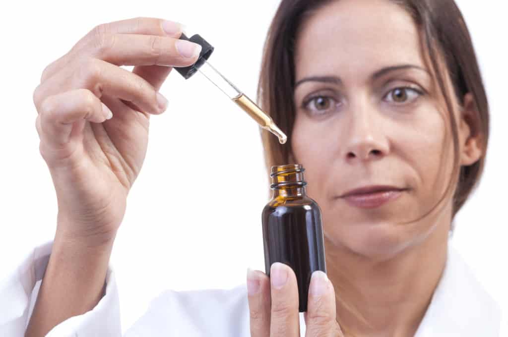 Woman with THC tincture bottle.