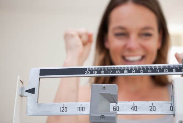 Girl on scale happy about her marijuana and weight loss results