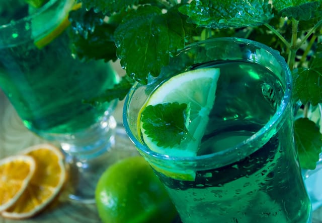 Liquid marijuanas drink in a shot glass with lemon slice.