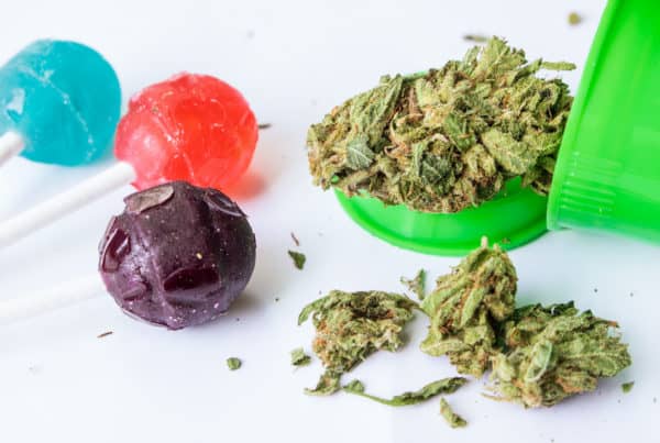 How to make thc candy. weed in green bowl next to colorful suckers, how to make THC candy
