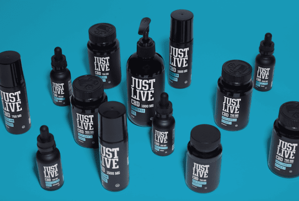 cbd tinctures and oil spread out on blue surface, just live cbd review