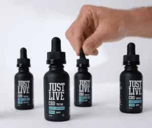Just Live CBD Review and Coupon 2 cbd oil tinctures with hand squeezing one