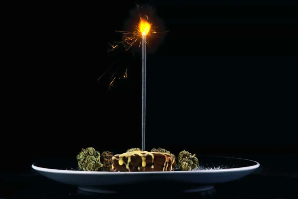 pot brownie plate with different marijuana buds and birthday candle, birthday cake
