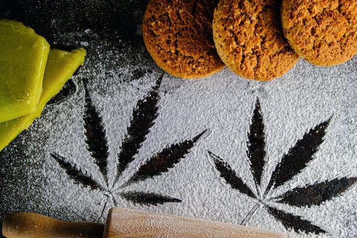 traces of marijuana leaves on flour, and rolling pin and three cookies and cannabis butter, white cookies strain