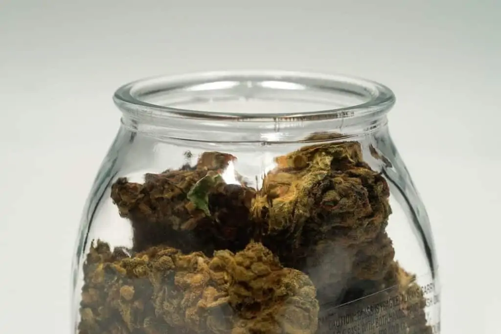brown cannabis buds in glass jar, marijuana legalization