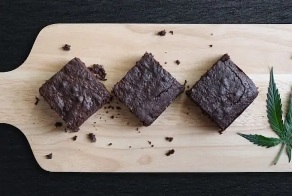 Dark Chocolate Homemade Brownies Infused with Medical Cannabis, with Marijuana leaf on wooden tray, weed recipes