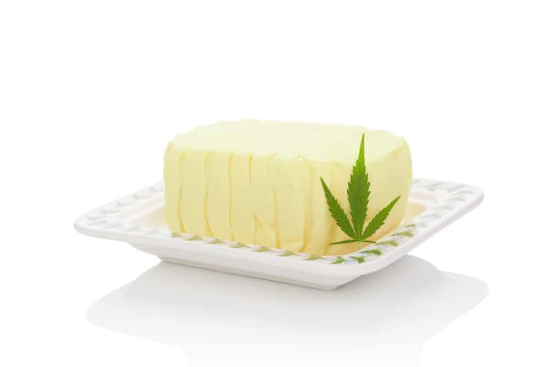 butter on white dish with cannabis leaf, how to make THC gummies with cannabutter