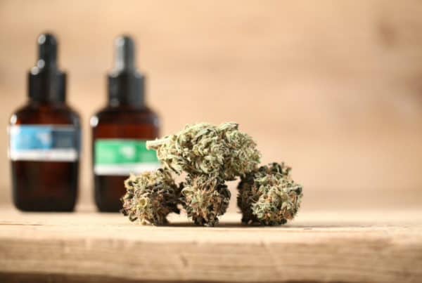 cannabis buds on wood table next to tinctures, is marijuana a depressant or stimulant
