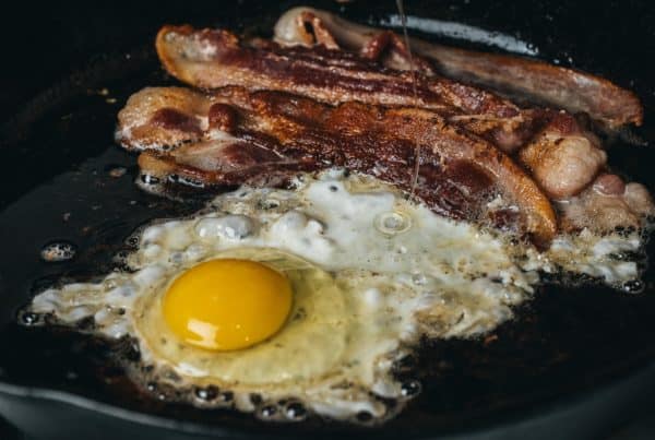 an egg and bacon cooking in pan, weed bacon