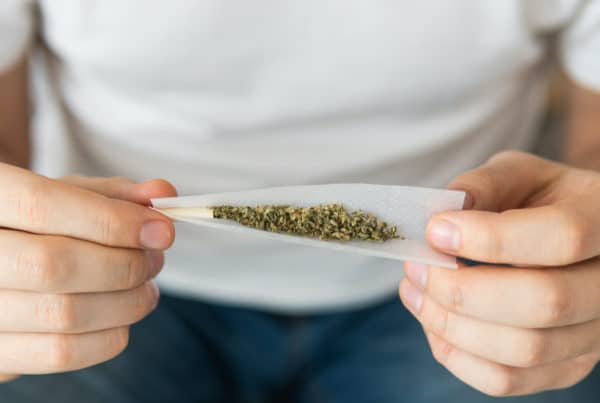 man rolling weed in paper, does marijuana stunt growth