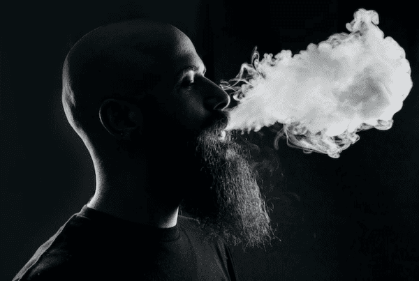 black and white of man blowing smoke, Hyde vape