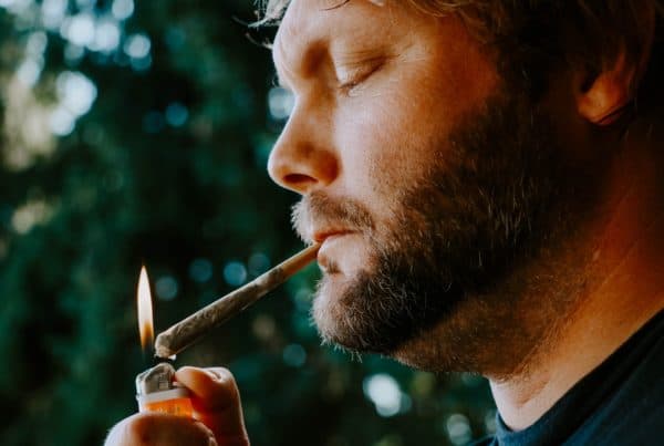man lighting a joint, marijuana eyes