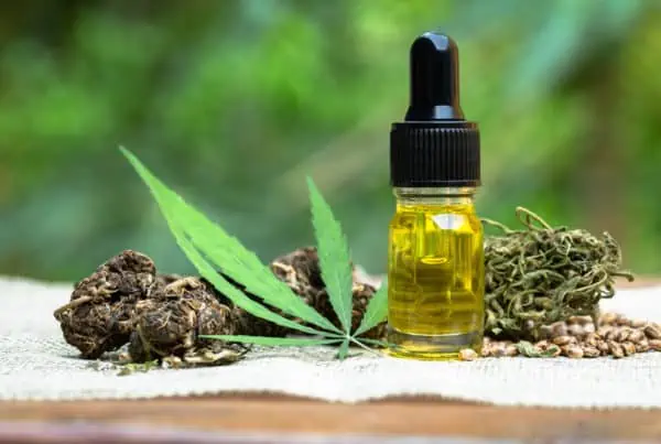 cbd tincture on table next to cannabis, how to flush cbd out of your system