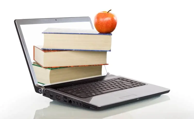 books stacked on a laptop with an apple