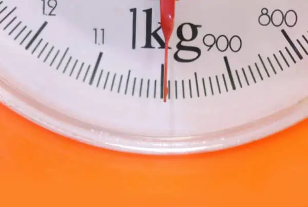 scale on orange background, how many grams are in a kilogram