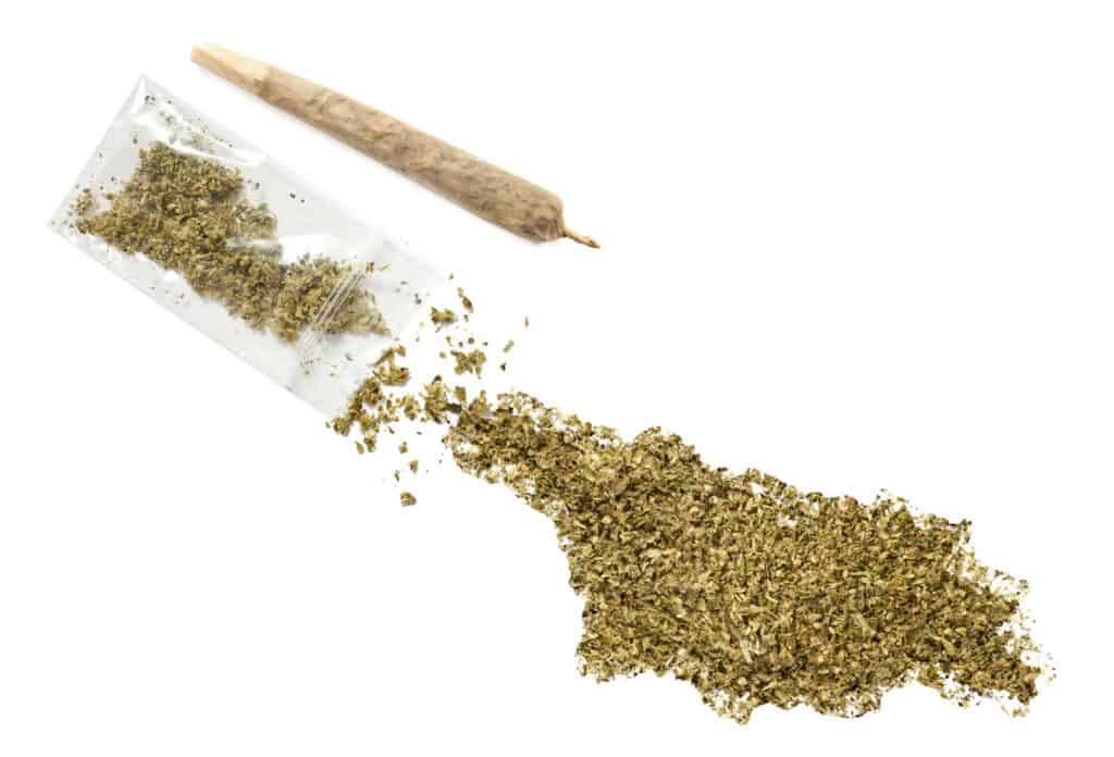 Is weed legal in Georgia? A map of Georgia made out of dried cannabis and a joint next to it. 