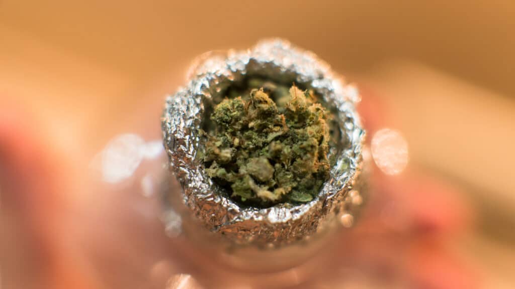 Mob Boss strain in a bowl in a plastic bottle with tin foil around the bowl