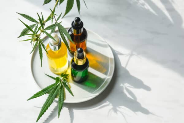 cbd oil on a tray with cannabis surrounding it