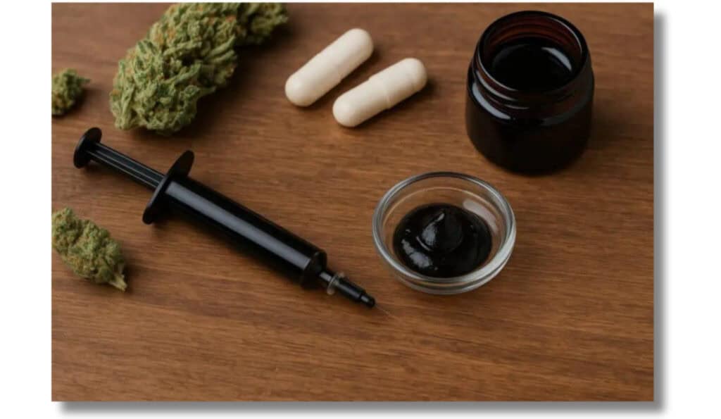Ultimate Guide to RSO (Rick Simpson Oil) 1 RSO-Rick Simpson Oil syringe, and capsules on a table with some cannabis.